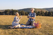 © pucko_ns - Couple mature woman and man sitting on blanket and make a picnic at the middle of the field in nature