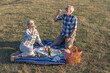 © pucko_ns - Couple mature woman and man sitting on blanket and make a picnic at the middle of the field in nature