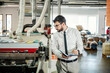© Dusan Petkovic - A print shop manager assesses quality of prints in printing machine.