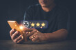 © krungchingpixs - Customer satisfaction and service quality survey concept, Businessman pointing a face and star icon to assess satisfaction with product and services on a virtual screen, Average level.