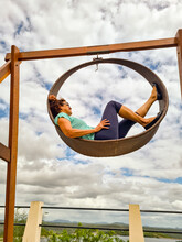 Woman Suspended In A Circular Rocking Chair