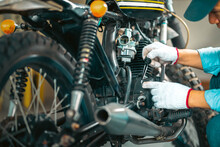 Choseup Man Mechanic In Garage Or Workshop Inspecting Classic Motorcycle During The Maintenance And Checks Oil Level.