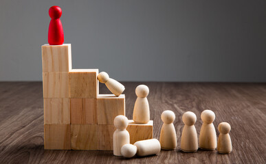  Wooden people figures on top of wooden blocks. Career growth, development and leadership