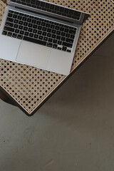 Wall Mural - Flatlay of laptop computer on rattan chair. View from above. Flat lay, top view