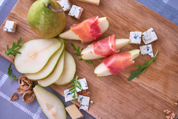 Wall Mural - Jamon or prosciutto ham slices, Blue cheese, pears and walnuts on wooden board