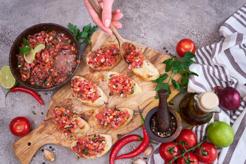 Wall Mural - Making bruschetta with freshly made salsa dip sauce