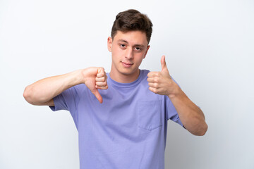 Young handsome Brazilian man isolated on white background making good-bad sign. Undecided between yes or not