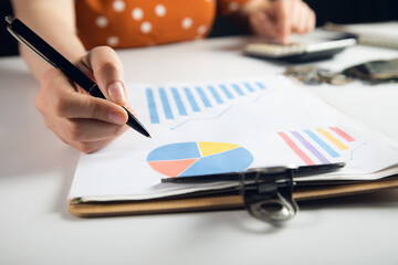 Wall Mural - Business woman counting on calculator and holding documents