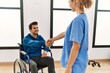© Krakenimages.com - Young disabled man and physiotherapist smiling happy shaking hands at the clinic.
