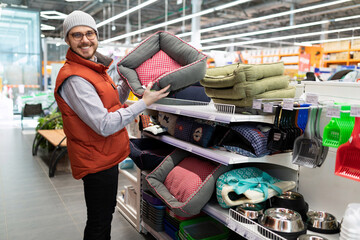 a caring owner chooses a bed for his cat or dog in a pet store