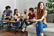 © Krakenimages.com - Group of young friends having party sitting on the sofa at home. Woman smiling happy using smartphone at home.
