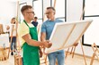 © Krakenimages.com - Group of middle age people drawing at art studio. Two students smiling happy holding canvas.