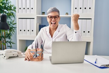 Poster - Middle age caucasian woman holding model of human anatomical skin and hair annoyed and frustrated shouting with anger, yelling crazy with anger and hand raised