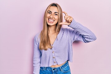 Sticker - Beautiful hispanic woman wearing casual shirt smiling and confident gesturing with hand doing small size sign with fingers looking and the camera. measure concept.