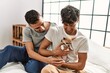 © Krakenimages.com - Two hispanic men couple hugging each other sitting on bed with chihuahua at bedroom
