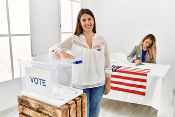 Sticker - Young brunette woman voting putting envelop in ballot box looking positive and happy standing and smiling with a confident smile showing teeth