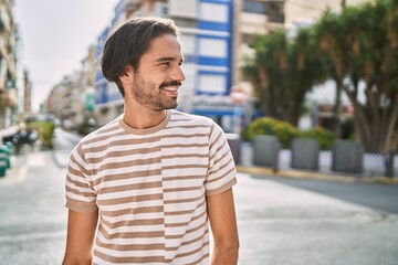 Wall Mural - Young hispanic man smiling confident at street