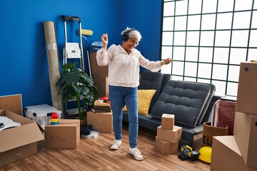 Sticker - Middle age woman listening to music and dancing at new home