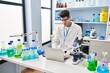 © Krakenimages.com - Young hispanic man wearing scientist uniform using laptop at laboratory