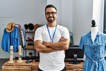 Sticker - Young hispanic man shopkeeper smiling confident standing with arms crossed gesture at clothing store