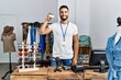 © Krakenimages.com - Young arab man shopkeeper holding credit card working at clothing store