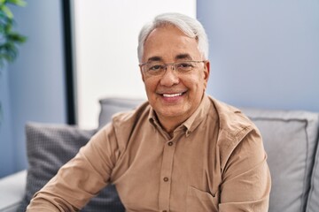 Wall Mural - Senior man smiling confident sitting on sofa at home