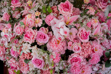 Big bouquet of flowers in a vase on a gray wall background