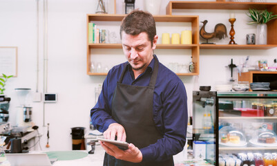 Male barista using tablet At the counter in cafes and restaurants Make your business more accessible with technology.