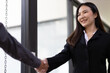 Handshake. Attractive Asian businesswoman with happy smiling face while shaking hands with coworker and agreeing business partnership.