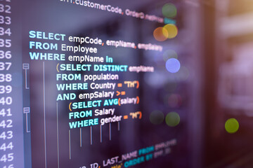 Wall Mural - sql (structured query language) code on computer monitor and server room background. example of sql 