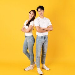 Wall Mural - Couple of teenage asian boy and girl together isolate on yellow background