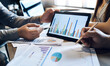 © Lek - Business concept. Business people discussing the charts and graphs in tablet computer about investment and business growth showing the results of their successful teamwork.