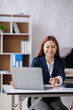 © David - Asian Business woman using calculator and laptop for doing math finance on an office desk, tax, report, accounting, statistics, and analytical research concept