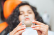 © inna717 - teen girl holding braces, dentist puts braces on girl. dental care and orthodontic concept.