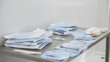 Medical laboratory details, a set of sterile disposable instruments lying on the table. Action. Close up of medical tools, surgical equipment, concept of medicine.