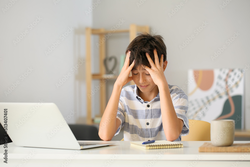 Stressed teenage boy learning at home