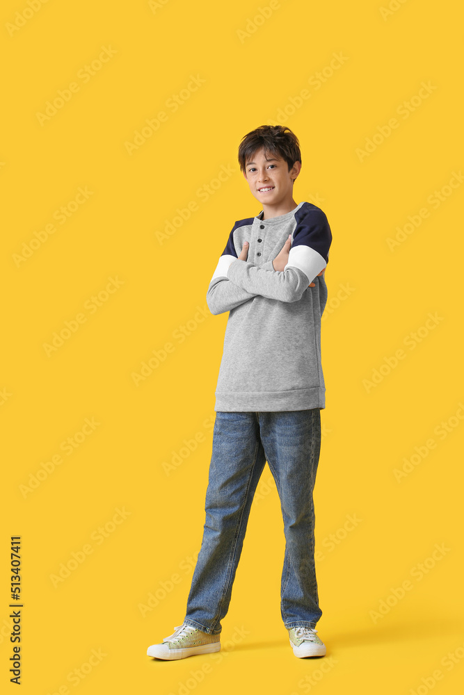 Teenage boy smiling on yellow background