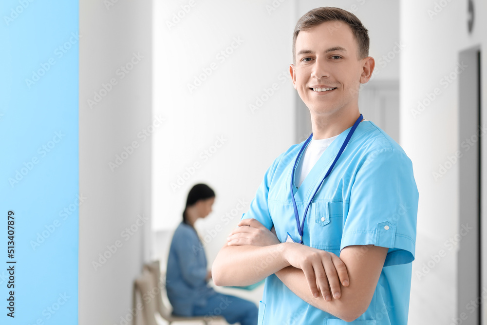 Male medical assistant smiling in clinic