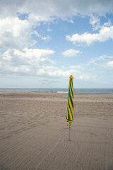 Wall Mural - Closed parasol on a cloudy day at the beach of pinamar, Buenos Aires, Argentina