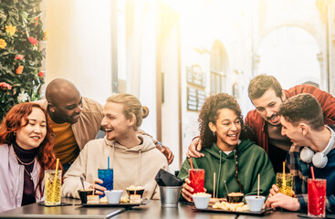 Friends group drinking and eating at coffee bar restaurant - People talking and having fun together at fashion cafeteria - Friendship concept with happy men and women at cafe - Selective focus .