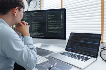 Wall Mural - software development concept, male programmer read data code to thoughtful about developing website