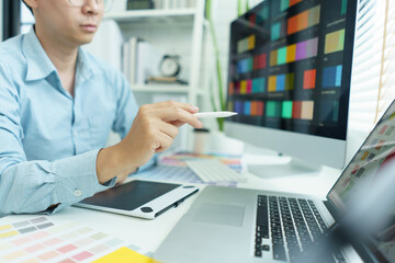 Wall Mural - creativity concept, male graphic designer pointing color swatch samples and drawing on tablet