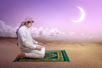 Wall Mural - Muslim man with keffiyeh with agal in praying position (salat) on the prayer rug