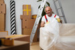 Leinwandbild Motiv Man mover in uniiform packing sofa for relocation