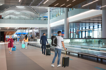 Poster - People with suitcases in airport terminal. Travelling by airplane