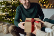© Westend61 - Smiling man giving gift to woman at home