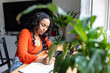 © Westend61 - Young woman writing in notebook at home office