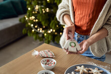 Woman Showing Packed Gingerbread Cookie On Table