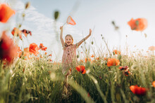 Happy Girl Chasing Butterflies In Poppy Field