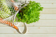 string bag with fresh vegetables. Fresh farm vegetables in mesh bag on wooden background. rustic style. Caring for environment, rejection of plastic. text space